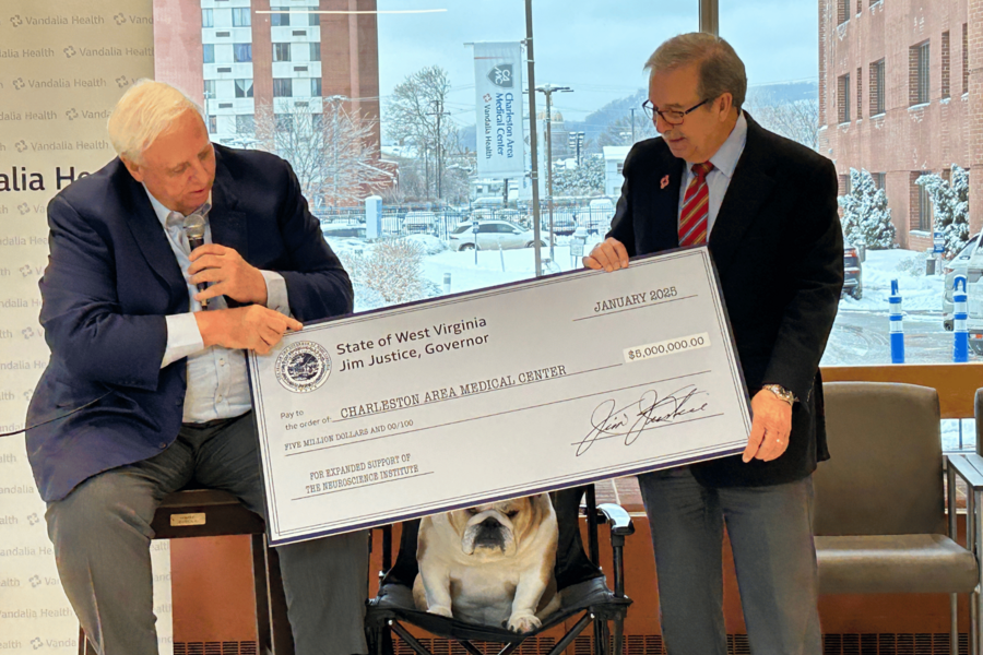 Governor Jim Justice handing Dave Ramsey a check for the new Vandalia Health Neuroscience Institute