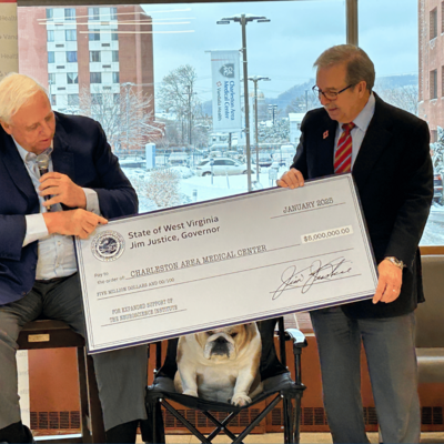 Governor Jim Justice handing Dave Ramsey a check for the new Vandalia Health Neuroscience Institute